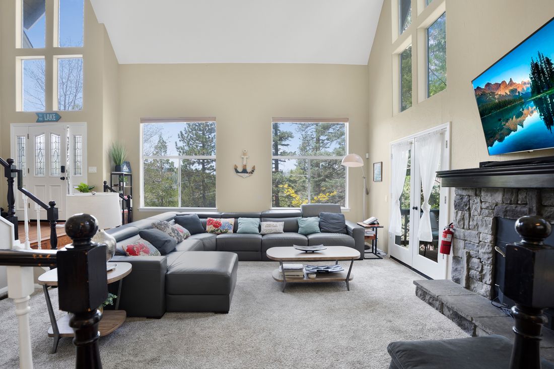 Open great room with tall windows looking out into the trees.