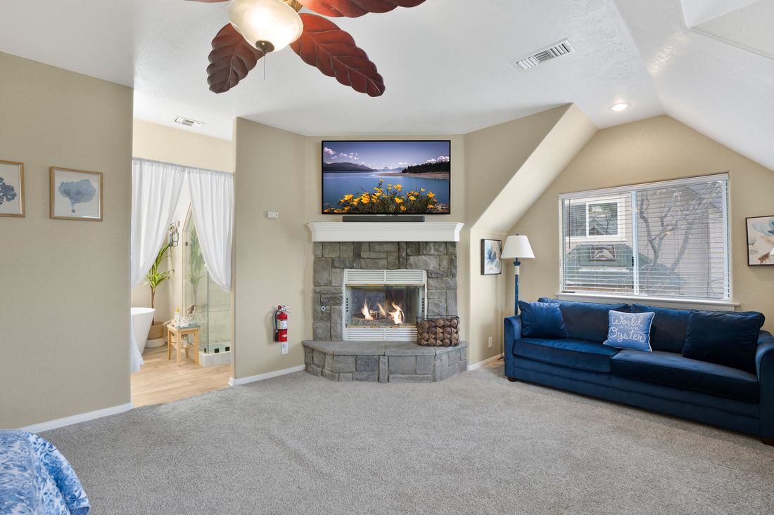 Primary bedroom with its own fireplace and vaulted ceiling.